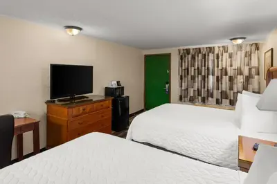 a hotel room with two beds and a flat screen tv at Knights Inn Ashland in Ashland