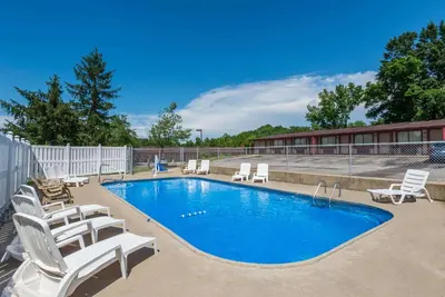 a swimming pool with lounge chairs next to a building at Knights Inn Ashland in Ashland