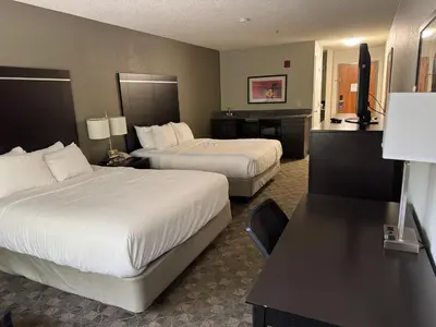a hotel room with two beds and a desk at Comfort Inn Huntington near University area in Huntington