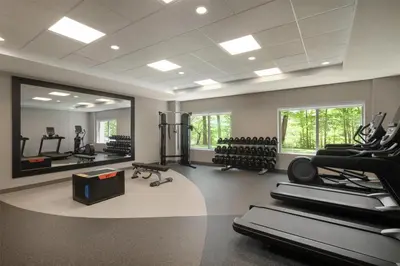 a gym with treadmills and exercise equipment and a mirror at Hilton Garden Inn Cleveland Airport in Fairview Park