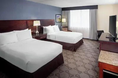 a hotel room with two beds and a television at Wyndham Independence in Independence
