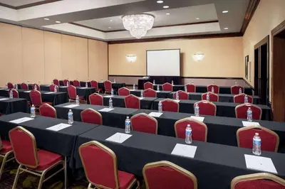 a conference room with tables and chairs and a screen at Wyndham Independence in Independence