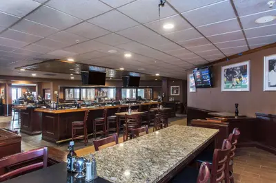 a restaurant with a bar with tables and chairs at Wyndham Independence in Independence