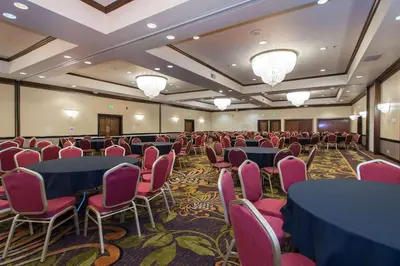 a conference room with blue tables and pink chairs at Wyndham Independence in Independence
