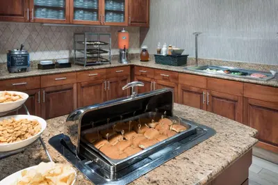 a kitchen counter with a sink and a bunch of rolls at Homewood Suites by Hilton Cleveland-Beachwood in Beachwood
