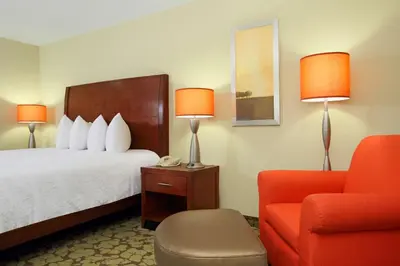 a hotel room with a bed and a chair at Hilton Garden Inn Columbus Airport in Columbus
