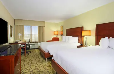a hotel room with two beds and a flat screen tv at Hilton Garden Inn Columbus Airport in Columbus