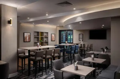 a restaurant with tables and chairs and a flat screen tv at Hilton Garden Inn Columbus Airport in Columbus