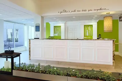 a lobby with two white garage doors and plants at Hilton Garden Inn Columbus Airport in Columbus