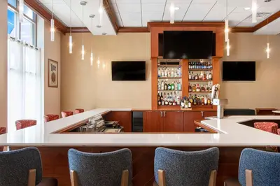 a bar in a restaurant with chairs and a tv at Hilton Garden Inn Cleveland Downtown in Cleveland