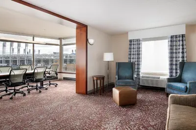 a conference room with a table and chairs and a room with a balcony at Hilton Garden Inn Cleveland Downtown in Cleveland