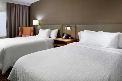 a hotel room with two beds and a chair at Hilton Garden Inn Columbus/Polaris in Columbus
