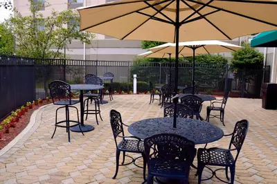 a patio with tables and chairs and an umbrella at Hilton Garden Inn Columbus/Polaris in Columbus