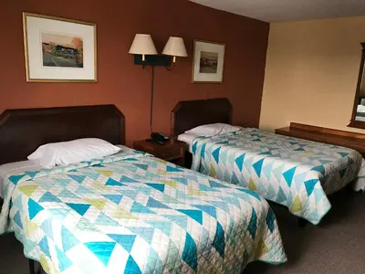 a hotel room with two beds in a room at Economy Inn in Fort Wayne