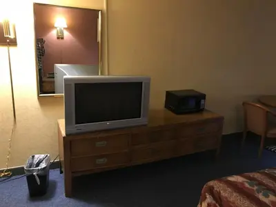 a television on a dresser in a hotel room at Economy Inn in Fort Wayne
