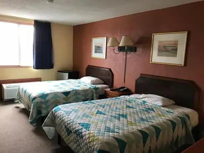 a hotel room with two beds and a window at Economy Inn in Fort Wayne