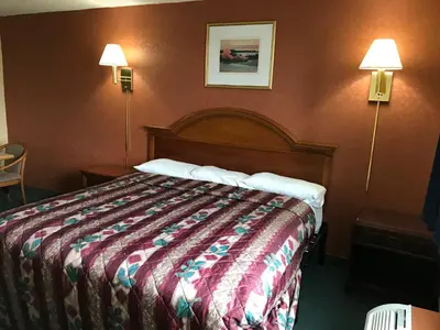 a hotel room with a bed and two lamps at Economy Inn in Fort Wayne