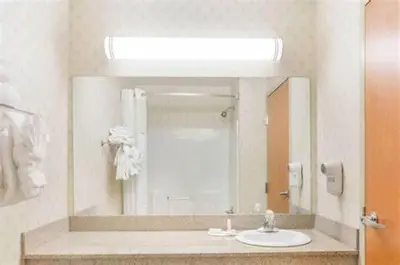 a bathroom with a sink and a mirror at Quality Inn Huntington University Area in Huntington