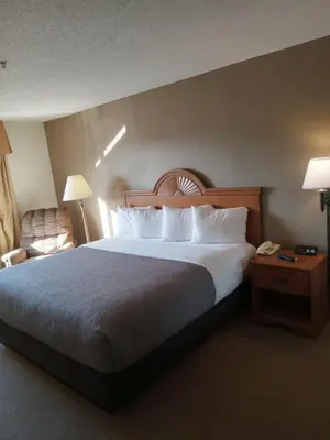 a hotel room with a large bed with white pillows at Quality Inn Huntington University Area in Huntington