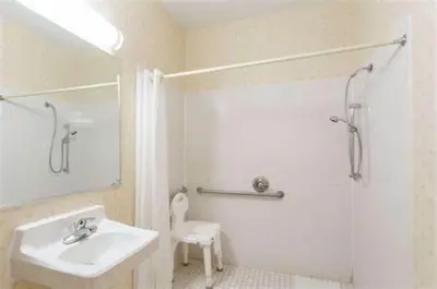 a white bathroom with a sink and a shower at Quality Inn Huntington University Area in Huntington