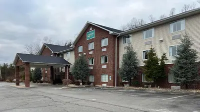 a large red brick building with a parking lot at Quality Inn Huntington University Area in Huntington