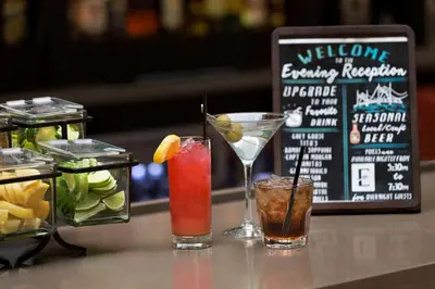 three cocktails sitting on a counter in a restaurant at Embassy Suites by Hilton Columbus in Columbus