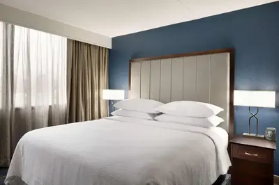 a bedroom with a large bed with white sheets and pillows at Embassy Suites by Hilton Columbus in Columbus