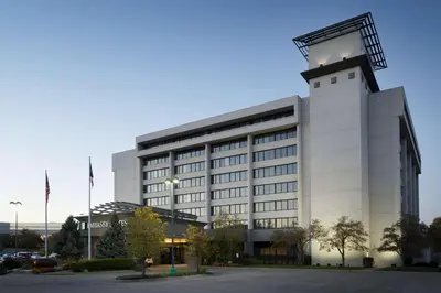 a large white building with a clock tower at Embassy Suites by Hilton Columbus in Columbus