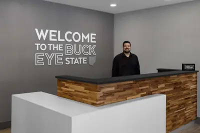 a man standing behind a reception desk at Hampton Inn Cleveland-Downtown in Cleveland