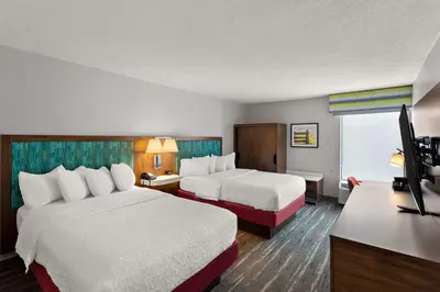 a hotel room with two beds and a desk at Hampton Inn Bridgeport/Clarksburg in Bridgeport