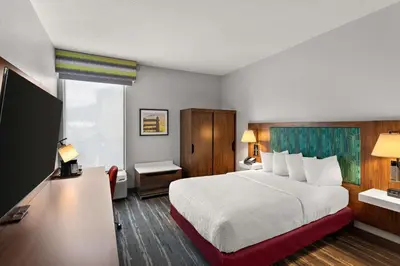 a hotel room with a bed and a flat screen tv at Hampton Inn Bridgeport/Clarksburg in Bridgeport