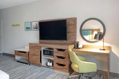 a room with a tv and a desk and a mirror at Hampton Inn Cleveland-Airport/Tiedeman Road in Brooklyn
