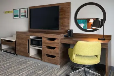 a room with a desk with a television and a chair at Hampton Inn Cleveland-Airport/Tiedeman Road in Brooklyn