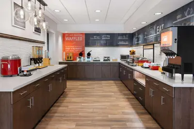 a large kitchen with wooden cabinets and a counter top at Hampton Inn Cleveland-Airport/Tiedeman Road in Brooklyn