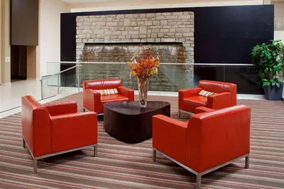 a lobby with red chairs and a fireplace at Wyndham Columbus in Worthington