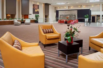 a lobby with yellow chairs and a table with flowers at Wyndham Columbus in Worthington