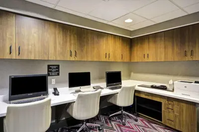 a conference room with a desk with two computers and chairs at Hampton Inn & Suites Columbus-Easton Area in Columbus