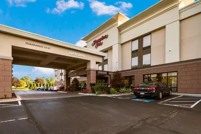 a hotel with a car parked in a parking lot at Hampton Inn West in Columbus