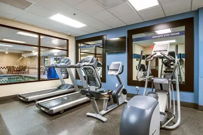 a gym with cardio machines and a swimming pool at Hampton Inn West in Columbus