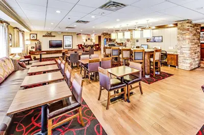a restaurant with tables and chairs and a couch at Hampton Inn Columbus I-70E/Hamilton Road in Columbus