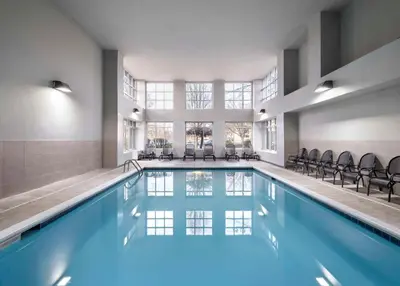 a swimming pool with chairs in a building at Homewood Suites Columbus - Airport in Columbus