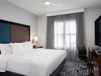 a hotel room with a large bed and a window at Homewood Suites Columbus - Airport in Columbus