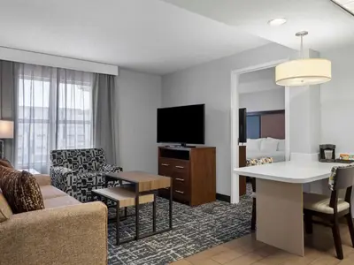 a living room with a couch and a room with a tv at Homewood Suites Columbus - Airport in Columbus