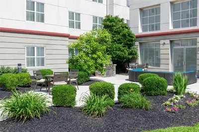 a courtyard with a table and chairs and plants at Homewood Suites Columbus - Airport in Columbus
