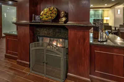 a fireplace in a bar in a hotel room at Hampton Inn Cambridge in Cambridge