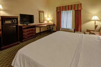 a hotel room with a bed and a desk and a television at Hampton Inn Cambridge in Cambridge