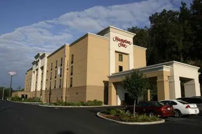 a building with a car parked in a parking lot at Hampton Inn Cambridge in Cambridge