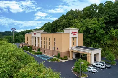 a building with cars parked in a parking lot at Hampton Inn Cambridge in Cambridge
