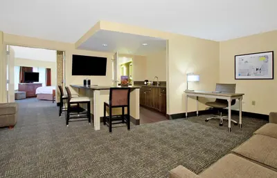 a hotel room with a table and a desk with a laptop at Hampton Inn & Suites Columbus-Downtown, Ohio in Columbus