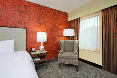 a bedroom with a bed and a chair and a window at Hampton Inn & Suites Columbus-Downtown, Ohio in Columbus